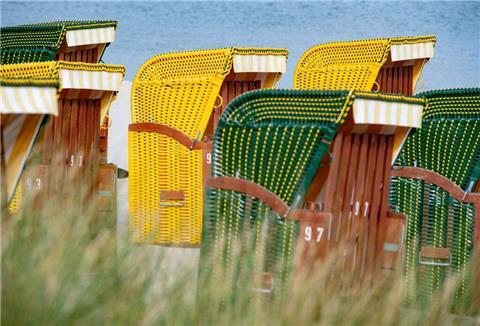 Strandkörbe stehen bei sonnigem Wetter am Strand auf der Insel Rügen.