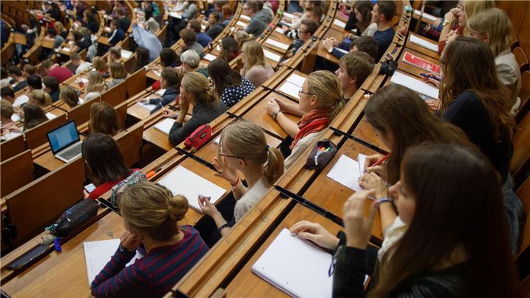 Studentenwerk fordert Zinsdeckelung beim KfW-Studienkredit Studenten und Studentinnen sitzen im Hörsaal und verfolgen eine Vorlesung.