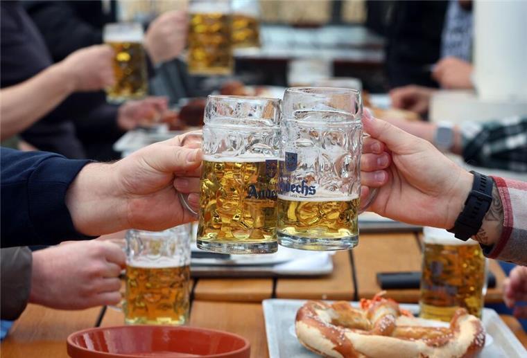 Menschen stoßen mit Bierkrügen an.