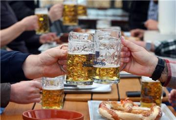 Menschen stoßen mit Bierkrügen an.