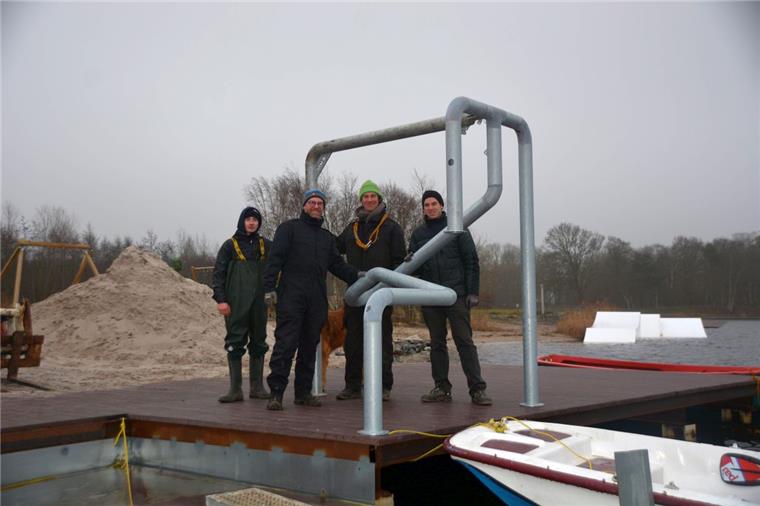 Stück für Stück nimmt das Wasserski-Angebot am Spadener See Form an. Hier errichten Hergen Hincke (von links), Tim Gebauer, Jan Brünjes und Daniel Ramin, den Bedienstand für die Anlage. Hund Reef (im Hintergrund) ist immer dabei. 
