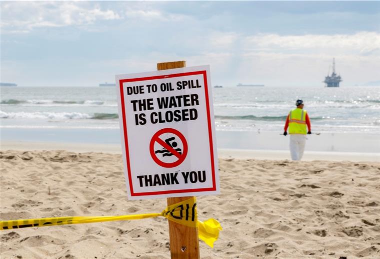 Ölpest in Kalifornien: Taucher finden Hinweise auf Ursache Ein Schild mit der Aufschrift "due to oil spill the water ist closed" ist am Strand aufgestellt.