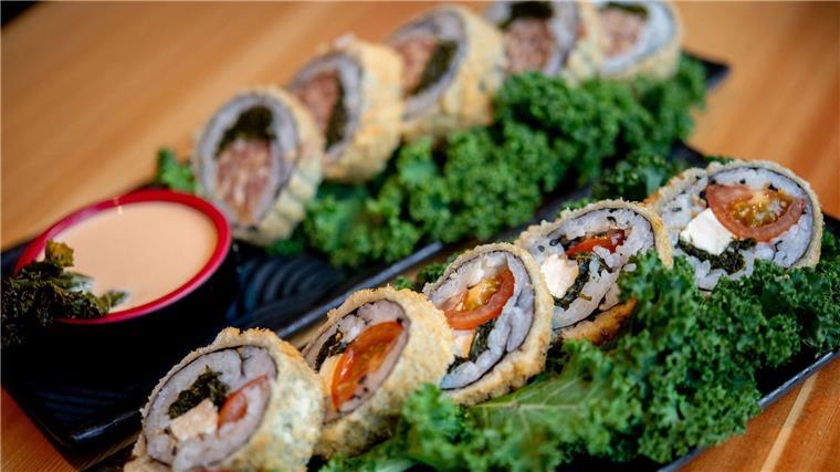 Traditionelles Gericht neu interpretiert: Grünkohl-Sushi Sushi mit Grünkohl, Tomaten und Feta (vorne) sowie Sushi mit Grünkohl und Pinkel steht im Restaurant Moto Kitchen auf einem Tisch.