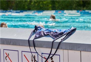Symbolbild: Ein Badeanzug liegt auf einer Mauer im Freibad.