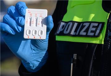 Symbolbild: Polizisten kontrollieren auf einer Straße Autos.