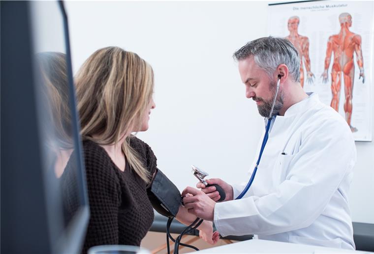 Hausarzt verursacht massenhaften Corona-Ausbruch Symbolfoto: Ein Hausarzt untersucht eine Patientin.