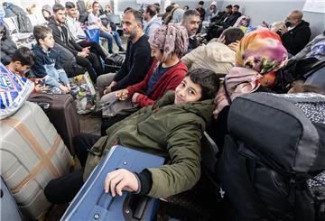 Symbolfoto: Flüchtlinge aus unterschiedlichen Ländern warten in einer Erstaufnahmeeinrichtung auf einen Bus.