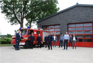 Symbolische Schlüsselgabe mit Corona-Sicherheitsabstand: Bürgermeister Thorsten Krüger (links) überreiche Ortsbrandmeister Steffen Heister den "Türöffner" fürs neue Feuerwehrhaus in Drangstedt.