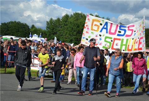 Teilnehmende der Gauß-Schule gehen mit einem bunten Banner auf die Strecke.