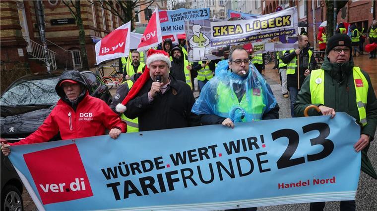 Lange Schlangen vor Weihnachten: Warnstreik im Einzelhandel Teilnehmerinnen und Teilnehmer eines Warnstreiks ziehen mit Fahnen der Gewerkschaft Verdi durch die Stadt.