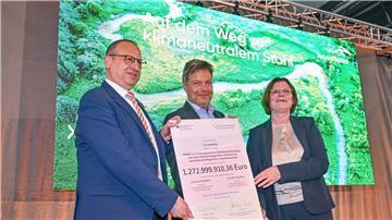 Thomas Bünger (l-r), CEO von ArcelorMittal, Robert Habeck (Grüne), Bundeswirtschaftsminister und Kristina Vogt (Die Linke), Bremer Senatorin für Wirtschaft, zeigen einen Fördermittelbescheid.