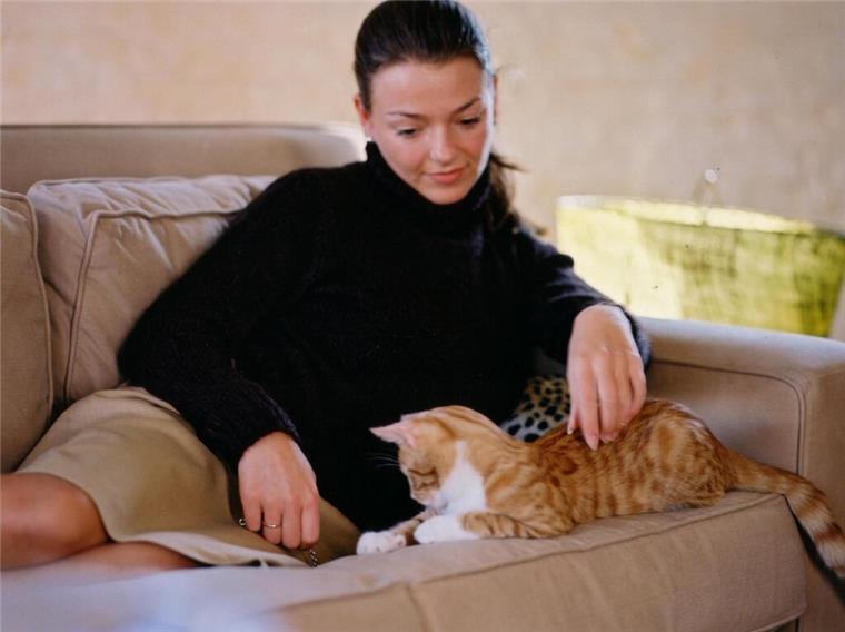 Tierliebe als Schlüssel zur Partnersuche: Der neue Dating-Trend Eine Frau liegt mit einer Katze auf einer Couch und kuschelt. Tiere sind nicht nur Begleiter, sondern können auch der Schlüssel zur Liebe sein. Der Boom spezialisierter Dating-Portale zeigt die wachsende Bedeutung.