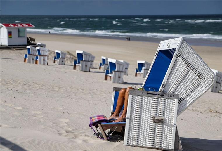 Touri-Schock an Nord- und Ostsee: Gäste bleiben weg und Hotels sind leer Eine Strandbesucherin liest bei sommerlichem Wetter ein Buch in einem Strandkorb
