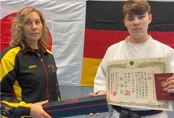 Traditionell wird der erste schwarze Gürtel nach bestandener Prüfung von der Trainerin übergeben. In diesem Fall übergibt ihn Mutter Dina Keller ihrem Sohn Konstantin.