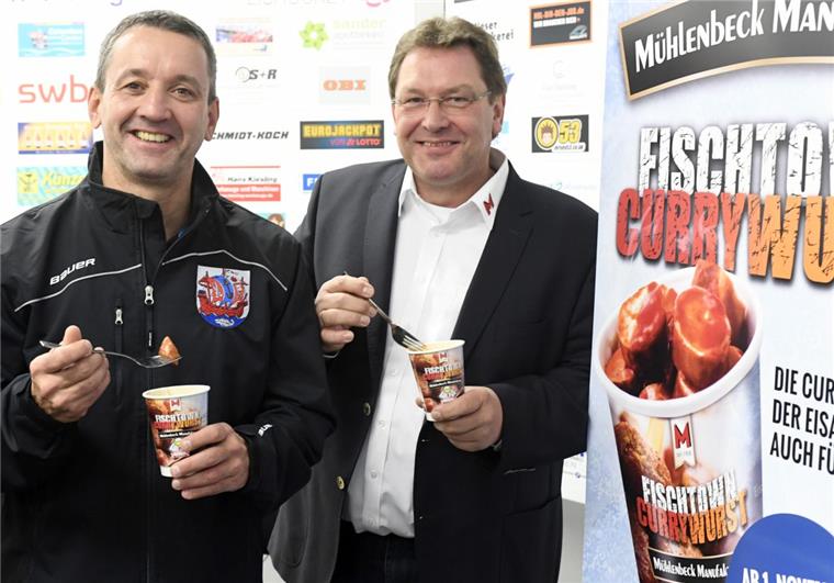 Fischtown-Currywurst ab November bei Edeka Trainer Thomas Popiesch (links) und Mühlenbeck-Chef Gebhard Buck probieren die neue Pinguins-Currywurst.