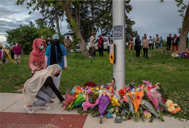 Auto-Attacke in Kanada: Vier Tote Trauernde legen Blumen an der Stelle ab, wo eine fünfköpfige Familie von einem Autofahrer angefahren wurde.