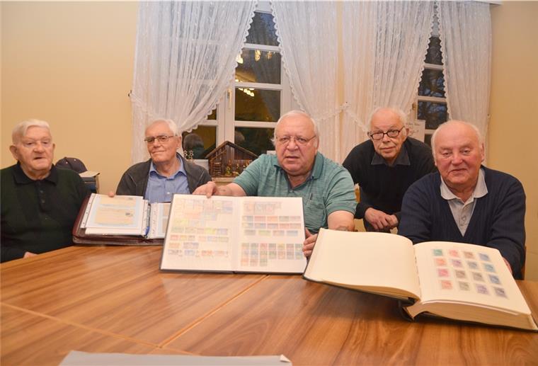 Fünf Senioren mit ihren Briefmarkensammlungen.