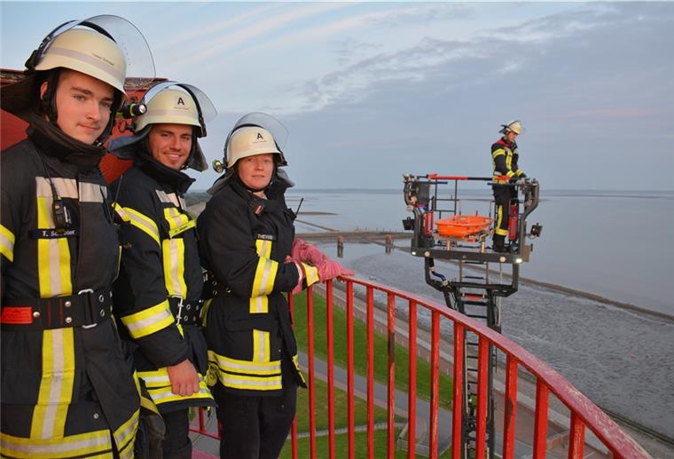 Butjadingen: Eckwarder Feuerwehr trainiert in luftiger Höhe Tristan Schröder, Damian Siegel und Gudula Thevißen (von links) erwarten in 34,50 Meter Höhe den Rettungskorb mit Drehleitermaschinist Tobias Bühring.