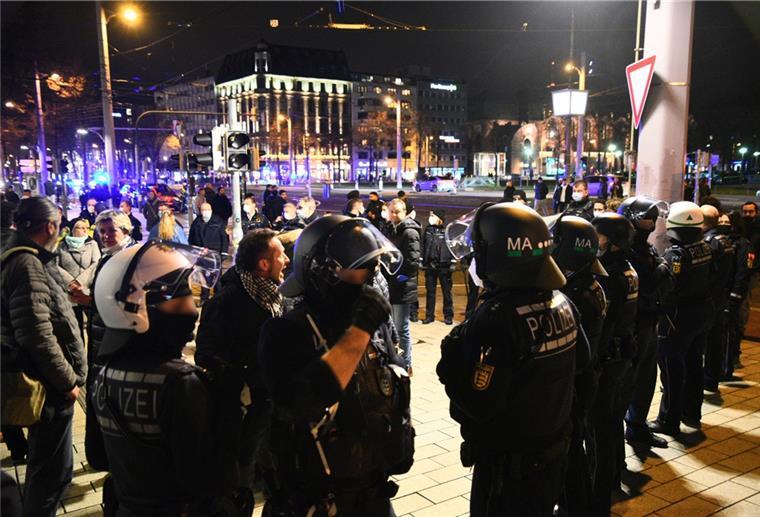 Demonstranten und Polizisten stehen in der Innenstadt. 