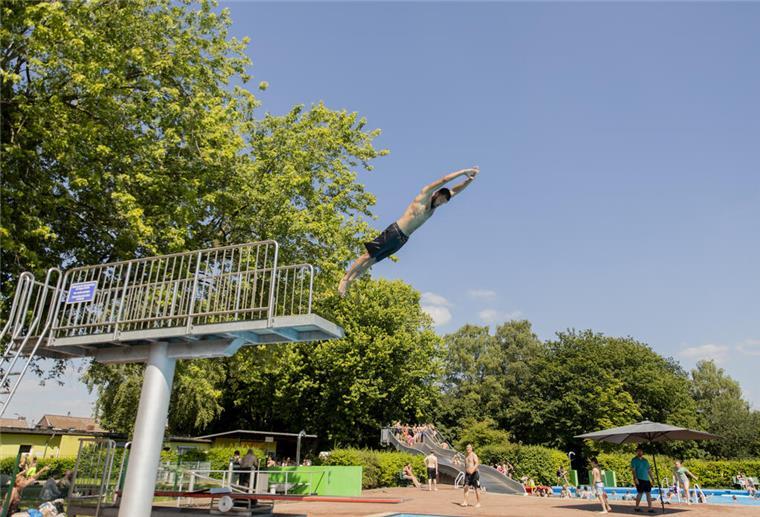 Freibadsaison startet mit Rap, SUP und freiem Eintritt in Bremerhaven Ein Sprungturm im Freibad Grünhöfe in Bremerhaven, von dem ein Mann in Badeshorts gestreckt abspringt.