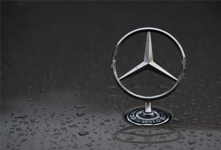 Sparhammer bei Daimler Truck: Tausende Mitarbeiter müssen um Job bangen Regentropfen sind auf einem Mercedes-Stern auf einem Fahrzeug zu sehen.