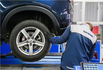 Ein Mitarbeiter vom TÜV repariert ein Auto. Der TÜV nimmt ältere Autos aufs Korn. Für sie sollen bald andere Regeln gelten.