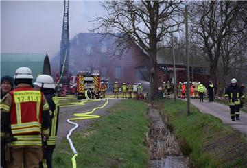 Einsatzkräfte der Feuerwehr kämpfen gegen einen Brand auf einem Bauernhof in Stadland.