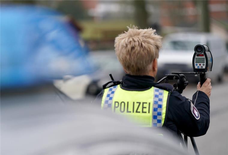 Eine Polizistin nimmt eine Geschwindigkeitsmessung in einer 30-Zone mit einem Laser an einer Straße vor.