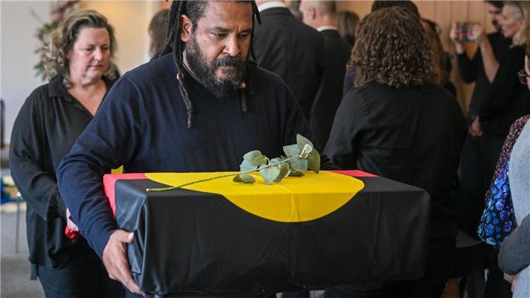 Menschliche Überreste aus Museen an Australien zurückgegeben Überreste eines der Ahnen werden aus dem Raum getragen.