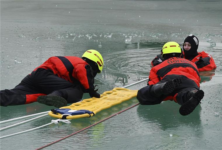 Übung im Watt'n Bad: In den Überlebensanzügen halten es die gespielten Unfallopfer einige Zeit im Eisloch aus, bis die Kollegen zur Rettung kommen.