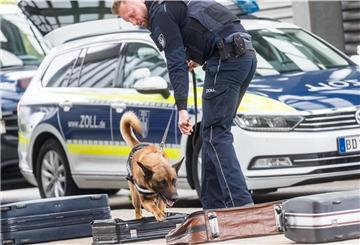 Übungssituation mit Spürhund: Zoll-Mitarbeiter suchen während ihrer Tätigkeit nach Drogen.