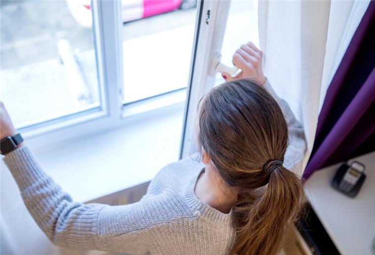 Energiesparen: Fenster nicht gekippt lassen Frau öffnet Fenster