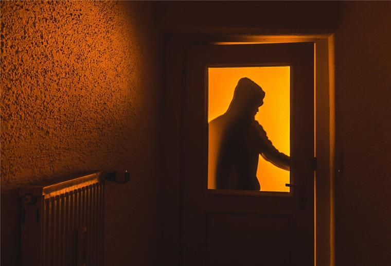 Bremerhaven: Nach Einbruch fehlt ein kompletter Tresor Die Silhouette eines Mannes mit Kapuze ist hinter einer Scheibe zu sehen.