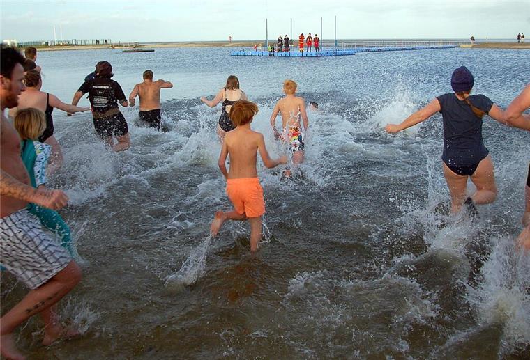 In Burhave springen 200 Mutige in die Nordsee-Lagune Erwachsene und Kinder laufen in eine Badelagune.