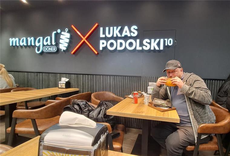 Podolskis Cyber-Döner: Poldis Hightech-Kebab soll Fast-Food-Markt erobern Ein Mann isst einen Döner Kebab in einem Laden von Ex-Fußballstar Lukas Podolski.