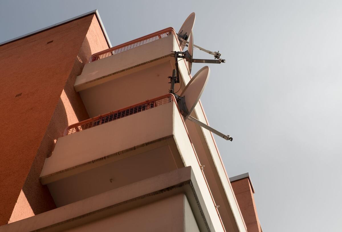 Mehrere Balkone mit Satellitenschüsseln.