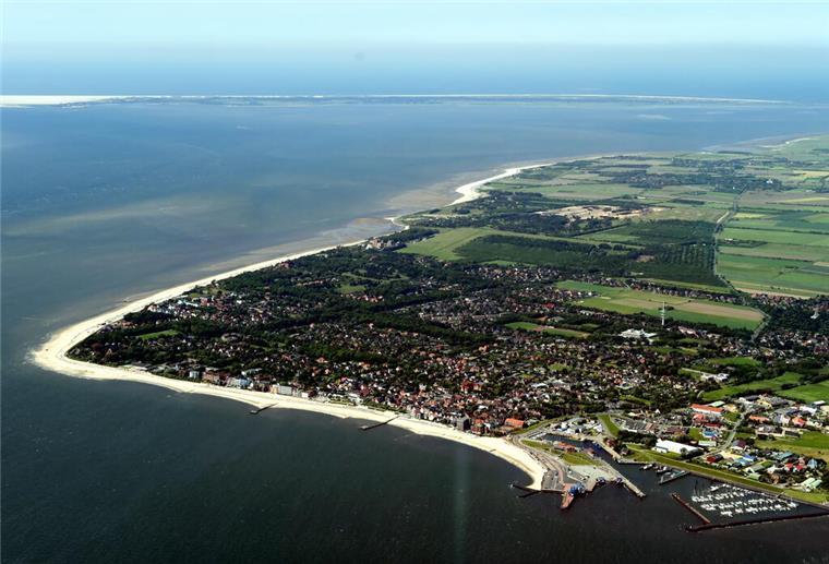 Die Luftaufnahme zeigt die Insel Föhr vor der Nordseeküste von Schleswig-Holstein. Urlaub auf Föhr muss nicht teuer sein: Mit Bollerwagen, Buchungslücke und Heubett lässt sich die Nordseeinsel günstig genießen.