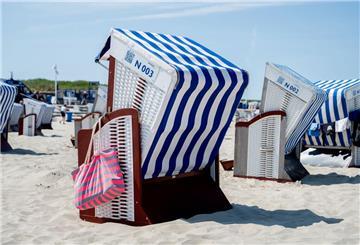 Eine Strandtasche hängt bei sonnigem Wetter an einem Strandkorb am Nordstrand der Insel. (zu dpa: «Eine Woche Urlaub für Millionen Menschen unbezahlbar»)