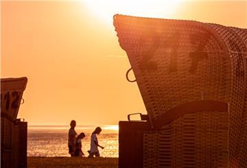 Urlauber genießen den Sonnenuntergang an der Wurster Küste 