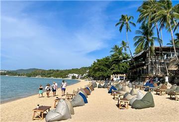 Urlauber spazieren am Strand in Bophut auf der thailändischen Insel Koh Samui.