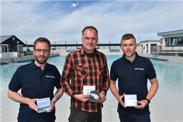 Uwe Evering präsentiert stolz mit den Schwimmmeistern Dirk Pape (links) und Niklas Kuske (rechts) die CD "Musik von hier" mit dem eigens für das Bad produzierten Song "Watt´n Bad".