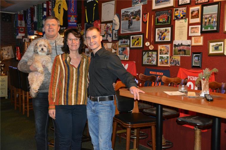 Geestland: "Ankeloher Hof" startet 2019 mit neuem Betreiber Uwe Gosda (von links) und Ehefrau Nicole ziehen sich hinter dem Tresen in Ankelohe zurück, wollen mitsamt Kneipenhund "Pauli" aber gerne Gäste bleiben in der Sportkneipe "Ankeloher Hof". Die Zapfhähne fest in der Hand hat künftig Daniel Stemmermann.