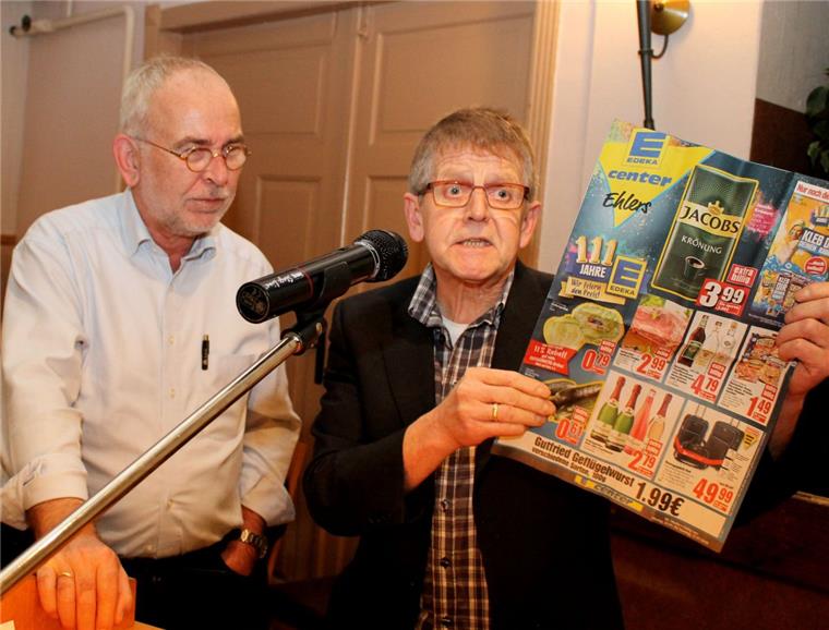 Uwe Hellmers (rechts) aus Klein Ippensen präsentiert Bauer Willi einen Billig-Angebote-Prospekt.