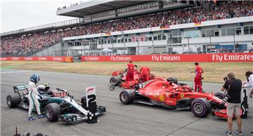 Valtteri Bottas (von links) aus Finnland und Sebastian Vettel und Kimi Räikkönen aus Finnland vom Team Scuderia Ferrari stehen nach dem Qualifying auf dem Hockenheimring. 