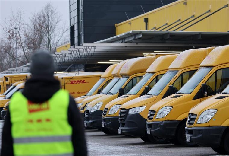 Am Zustellstützpunkt der Deutschen Post DHL am Hauptbahnhof haben sich die Mitarbeiter zum Warnstreik eingefunden, im Hintergrund stehen die Zustellfahrzeuge.