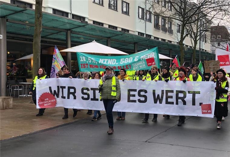 Menschen laufen durch die Straßen und halten Banner hoch.