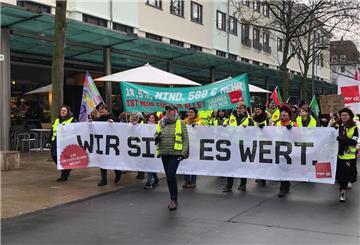 Menschen laufen durch die Straßen und halten Banner hoch.