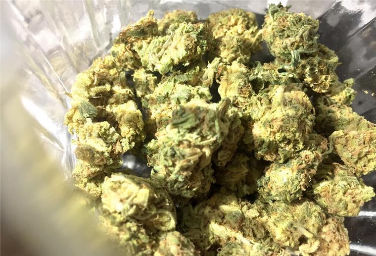 Cannabisblüten liegen in einem Glas.