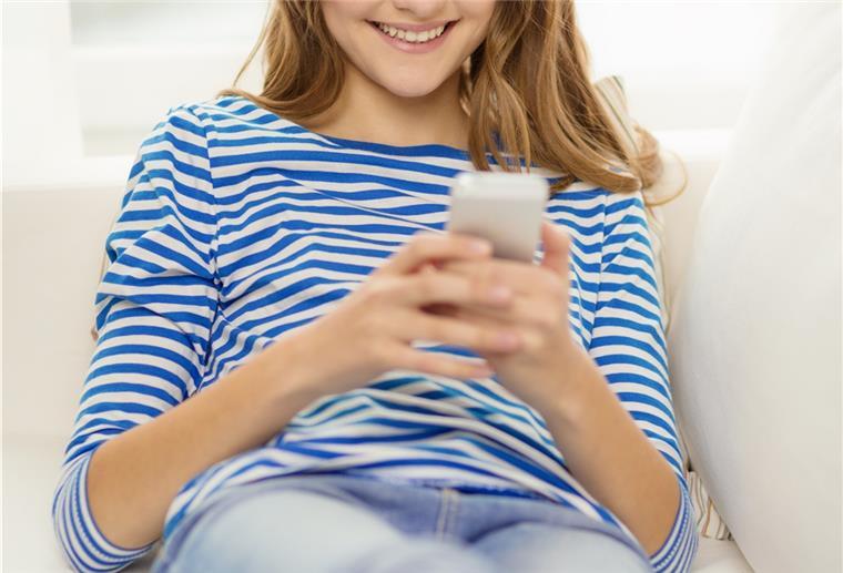 Frau schaut auf das Smartphone in der Hand