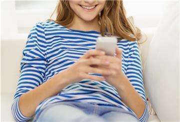 Frau schaut auf das Smartphone in der Hand